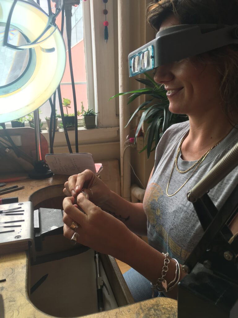 Christina B in the process of learning how to flush set a sapphire into a silver band